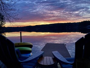 A calm lake mirrors a vibrant sunrise. 