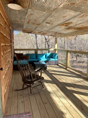 Upper deck that over looks creek and mountain with rocker and patio furniture  