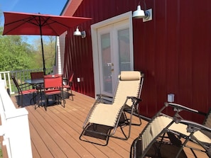 Deck off the bedroom with outdoor dining table and lounge chairs.