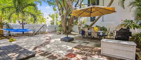 Beautiful yard features a hammock and outdoor dining table.