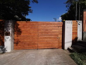 The gate to a very private property with parking and a beautiful garden