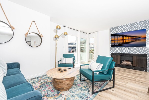 The main living area includes seating area, streaming TV, and sliding doors out to the front patio.
                