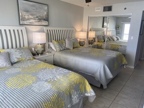 Master bedroom with two queen beds with sliding doors that open to the balcony