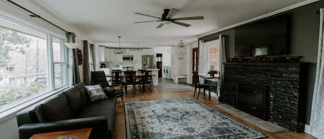 Living room has gas fireplace, 65" TV and ceiling fan.