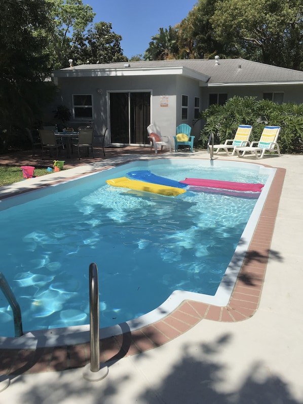 15' x 30' private backyard pool, with rafts, chairs, children's sand toys.