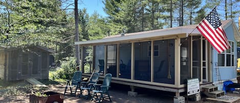 Front of Park Model w fire pit and screened in deck entrance