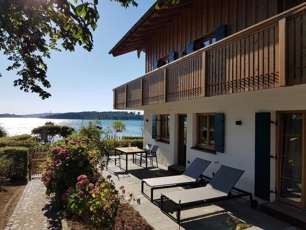 Garden Suite mit gemütlicher Wohnküche und Seeblick-Private Terrasse mit Essplatz für 6 Personen und zwei Liegen