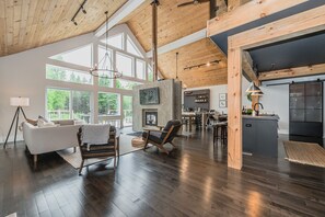 The modern great room provides easy access to. the open concept kitchen, main floor bedrooms and more. 