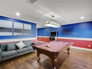 Looking for some friendly competition? This game room features a classic pool table and a retro arcade machine!