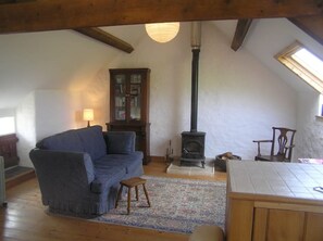 living area with wood stove and sea views from roof windows