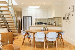 [Dining Area] Open-plan dining with a 6-seater wooden dining table opens onto the living kitchen.