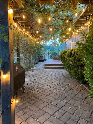 Entrance is laced with wisteria and string lights.