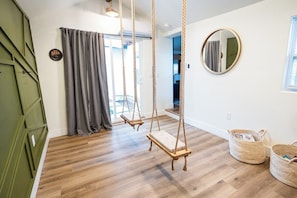 Swings for the kiddos and adults under 150 pounds. This room connects to the back yard  for extra entertaining. 