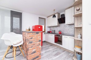 Fully equipped kitchenette with a fridge with freezer, electric kettle, induction hob, washing machine and dining area.