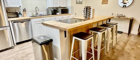 Kitchen is equipped with cooking essentials, olive oil, and an array of spices.