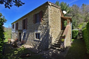 La propriété en pierre et le jardin bien entretenu