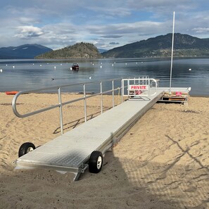 Large dock with railing for safety and ladder for swimming & buoy in lake