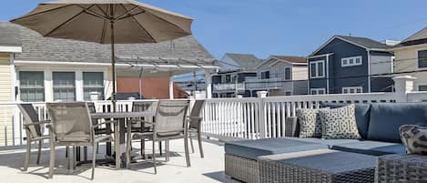 Enjoy the spacious outdoor deck with dining table, umbrella and sofa sectional