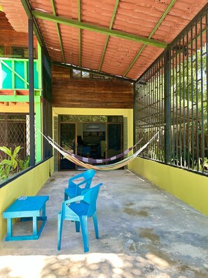 outside patio area w Gulfo Dulce view.  2 hammocks and 2 chairs with a table