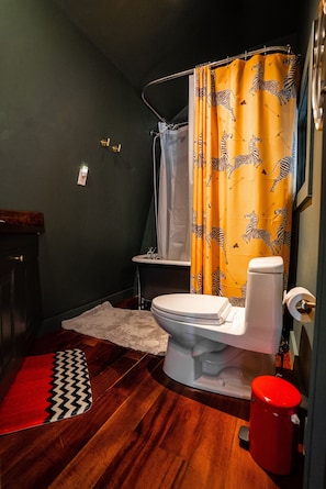 Bathroom toilet and antique cast iron bathtub and shower fixture