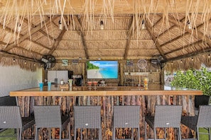 This tiki bar has entertainment with plenty of seating for the game