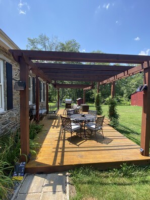 Pergola deck with dining table, lounge seating and a great, new gas grill.