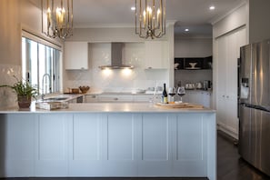 Large modern kitchen and butler's pantry with waterfall stone benchtops 