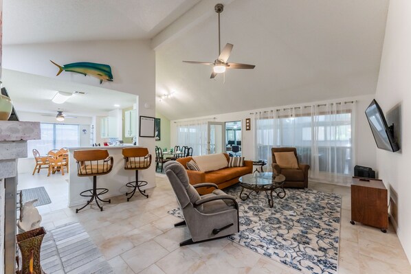 High-ceiling, open-space living room, with stone floors.