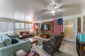 Large gameroom, with workout equip, work desk, and access to backyard.