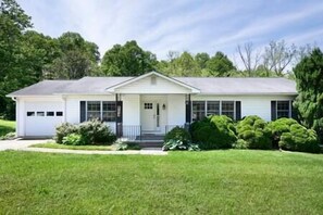 Front of the home with yard and driveway for four large vehicles (or 6+ if smaller)