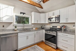 Bright kitchen with access to backyard & patio, skylight, peekabo water view