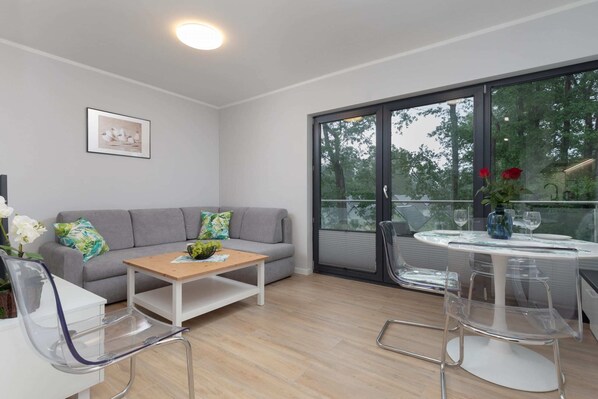 The living area features a sleek coffee table and a flat-screen television.