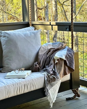 Enjoy the outdoors in comfort from the swinging cushioned porch bench!