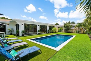 Relax in the private backyard, with amazing pool views day & night and amenities that include soft artificial turf, pool lounge chairs, umbrellas, outdoor dining table and a BBQ grill all surrounded by palm trees and tropical landscaping.