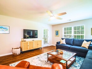 Living room with comfortable furniture and 55" smart TV. Opens to screened porch