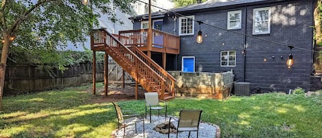 Fully fenced backyard with a deck and fire pit