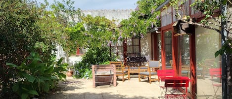 la cour arborée , son barbecue et son salon de jardin