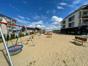 A sandy beach with sun loungers and vibrant surroundings, providing a seaside experience.
