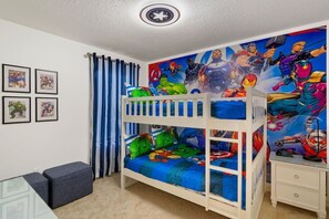 Exciting superhero-themed kids' room with vibrant decor and cozy bunk beds for an unforgettable stay!