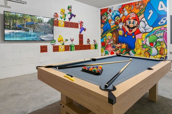Dive into fun in this vibrant Super Mario-themed game room with a pool table and entertainment area—perfect for gamers and families!