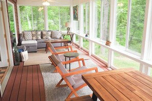 The best part of Corny Cottage might be the three-season porch, with floor-to-ceiling windows to soak up that amazing lake view. 