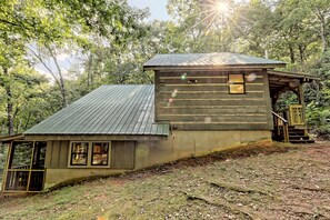 The split level cabin has a large porch at the front and at the back