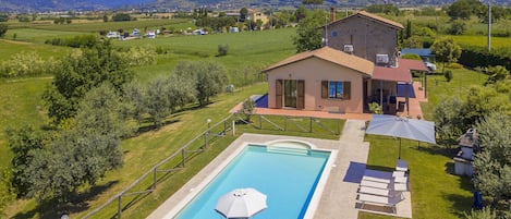 The property and the equipped pool surrounded by the well kept lawn