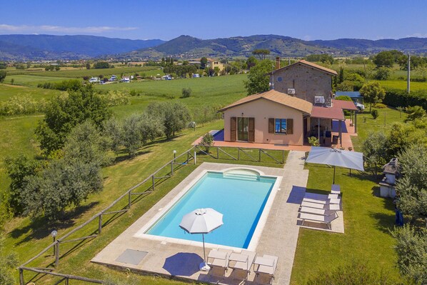 The property and the equipped pool surrounded by the well kept lawn