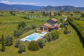 The property and the equipped pool surrounded by the well kept lawn