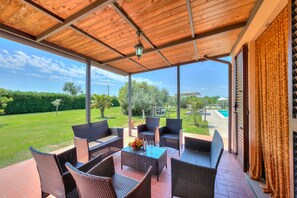 The equipped pergola open on the lawn and connected to the kitchen