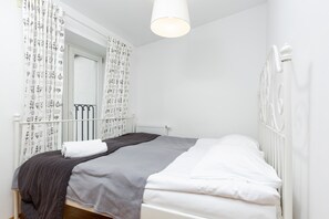 A serene bedroom with a white bedframe, soft linens, and neutral tones for a peaceful atmosphere.
