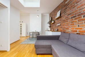 A view of the living area and kitchen, emphasizing the harmonious combination of brick and modern white finishes.
