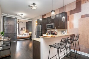 Fully furnished kitchen with all the necessities for basic cooking, including stainless steel appliances and a bar cart.