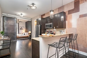 Fully furnished kitchen with all the necessities for basic cooking, including stainless steel appliances and a bar cart.